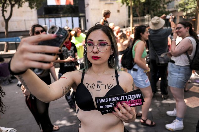 A demonstrator uses her phone to take a “selfie” picture during the 12th annual “SlutWalk” march through central Jerusalem on June 14, 2024 to protest against rape culture, including sеxual assault and harassment directed at women, and calling for an end to the ongoing war in the Gaza Strip and action to release hostages taken captive during the October 7 attacks. (Photo by Hazem Bader/AFP Photo)