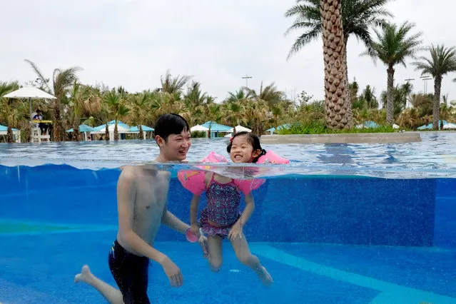 Hotel guest Lin Hongyu swims with his three-year-old daughter in a pool at Atlantis Sanya resort in Sanya, Hainan province, China on May 2, 2018. (Photo by Bobby Yip/Reuters)