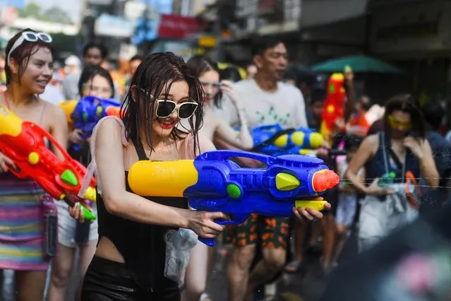A Chinese tourist plays with water as she celebrates during the Songkran holiday which marks the Thai New Year in Bangkok, Thailand on April 13, 2023. (Photo by Chalinee Thirasupa/Reuters)