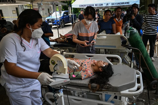 Hospital staff check on a patient outside a damaged hospital in Manay, in the province of Davao Oriental on October 11, 2025, after two powerful quakes struck off the southern Philippines on October 10, killing at least eight people and triggering tsunami warnings. (Photo by Jam Sta Rosa/AFP Photo)