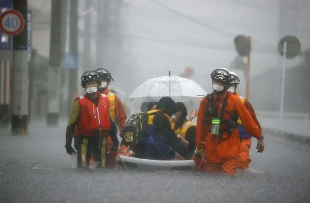 Firefighters carry stranded residents on boat in a road flooded by heavy rain in Kurume, Fukuoka prefecture, western Japan, August 14, 2021. As fossil fuel use that feeds climate change is creeping up around the world, Japan is set for another sweltering summer following last year’s dangerous heat waves and is at growing risk of flooding and landslides. (Photo by Kyodo News via AP Photo)
