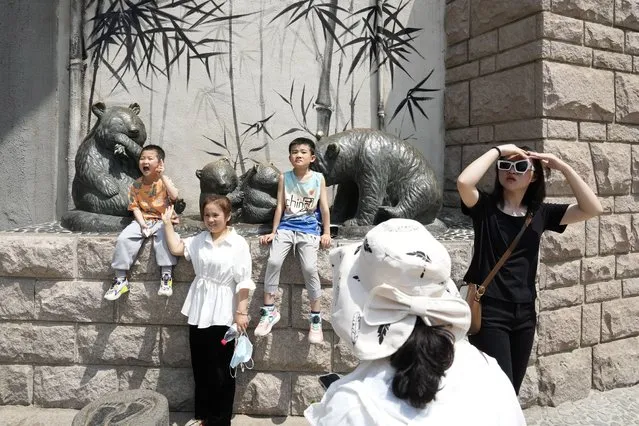 Visitors pose for photos near the Panda enclosure in the zoo on the last day of the May Day holidays in Beijing, Wednesday, May 3, 2023. (Photo by Ng Han Guan/AP Photo)