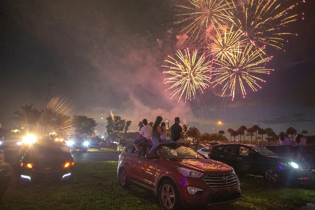 People watch the Independence Day fireworks show from their cars at the drive-in fireworks show presented by Hard Rock Stadium in Miami Gardens, Florida, USA, 04 July 2020. Most cities in Florida have canceled their traditional fireworks shows and the gatherings are discouraged to stop the spread of the virus. (Photo by Cristóbal Herrera/EPA/EFE)