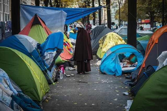 A woman looks on on November 3, 2016 in Paris near to the Stalingrad metro station, one of several camps sprouting up around the French capital. Less than 300 kilometres from the recently-demolished “Jungle” migrant camp in Calais, around 2,000 migrants are living in similar conditions on the streets of Paris. uthorities are expected to soon clear the camp under a railway bridge in the northeastern Stalingrad district, with a 400-bed temporary shelter set to open in the coming days. (Photo by Lionel Bonaventure/AFP Photo)