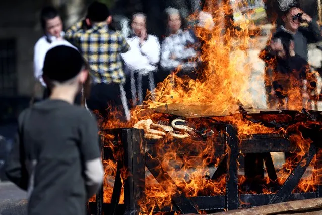 Ultra-Orthodox Jews burn leavened bread ahead of the upcoming Jewish holiday of Passover in the Mea Shearim neighbourhood of Jerusalem on April 5, 2023. (Photo by Ronen Zvulun/Reuters)