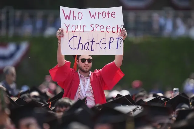 A person in a graduation cap and gown holds a sign during an address by David Zaslav, president and CEO of Warner Bros. Discovery, at Boston University commencement ceremonies, Sunday, May 21, 2023, in Boston. Many graduating students chanted slogans in support of the Hollywood writers' strike during the ceremonies. (Photo by Steven Senne/AP Photo)
