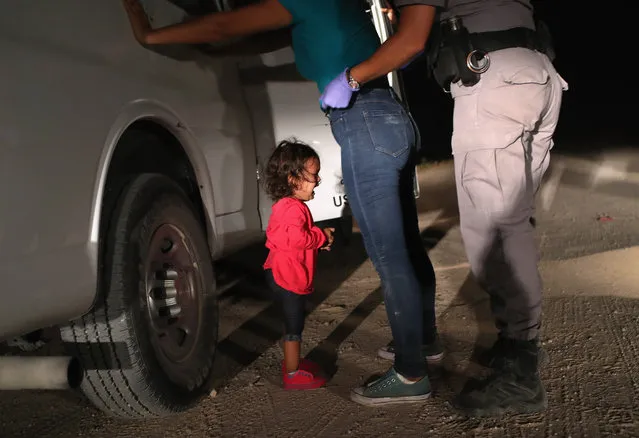 A two-year-old Honduran asylum seeker cries as her mother is searched and detained near the U.S.-Mexico border on June 12, 2018 in McAllen, Texas. The asylum seekers had rafted across the Rio Grande from Mexico and were detained by U.S. Border Patrol agents before being sent to a processing center for possible separation. Customs and Border Protection (CBP) is executing the Trump administration's “zero tolerance” policy towards undocumented immigrants. U.S. Attorney General Jeff Sessions also said that domestic and gang violence in immigrants' country of origin would no longer qualify them for political asylum status. (Photo by John Moore/Getty Images)