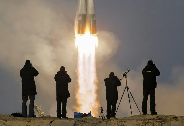 Photographers take pictures as the Soyuz TMA-19M spacecraft carrying the crew of Timothy Peake of Britain, Yuri Malenchenko of Russia and Timothy Kopra of the U.S. as it blasts off to the International Space Station (ISS) from the launchpad at the Baikonur cosmodrome, Kazakhstan, December 15, 2015. (Photo by Shamil Zhumatov/Reuters)