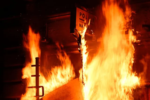 A photograph shows the frontage of a police station on fire during a demonstration, after France's Constitutional Council approved the key elements of French President's pension reform, in Rennes, western France, on April 14, 2023. France has been rocked by three months of demonstrations and strikes over Macron's bid to raise the retirement age to 64 from 62, with around two in three voters against the changes, according to polls. (Photo by Damien Meyer/AFP Photo)