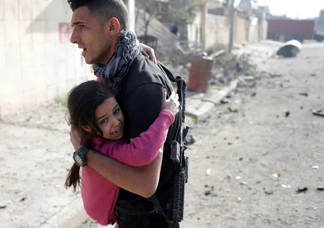 An Iraqi special forces soldier holds a girl injured by an Islamic State suicide car bomb attack in Tahrir neighbourhood of Mosul, Iraq, November 17, 2016. (Photo by Goran Tomasevic/Reuters)