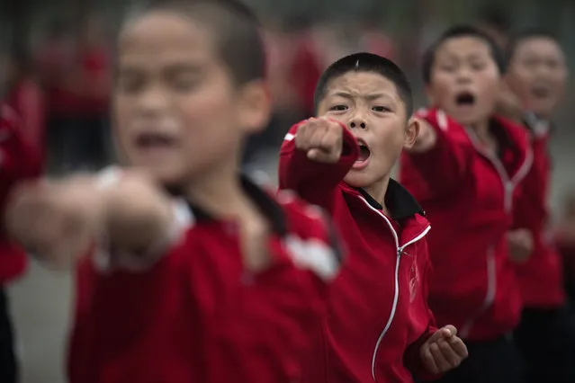 This picture taken on October 20, 2016 shows students practising wushu at the Tagou martial arts school in Dengfeng. China is investing hugely in football training and has vowed to have 50 million school- age players by 2020, as the ruling Communist party eyes “football superpower” status by 2050. Some 1,500 students from the vast Tagou martial arts school, a few miles from the cradle of Chinese kungfu, the Shaolin Temple in Henan province, have signed up for its new soccer programme, centred on a pristine green Astroturf football pitch where dozens of children play simultaneous five- a- side- games. (Photo by Nicolas Asfouri/AFP Photo)