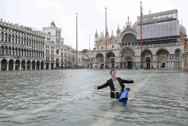 A man poses in a flooded St. Mark's Square during a period of seasonal high water in Venice, February 6, 2015. (Photo by Manuel Silvestri/Reuters)