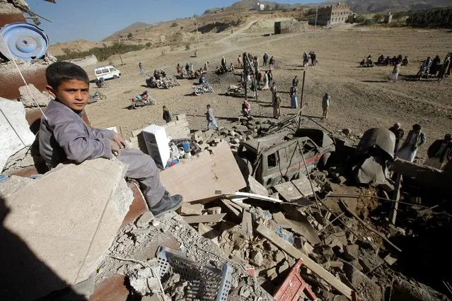 A boy looks at the camera as he sits on the wreckage of a house destroyed by a Saudi-led air strike on the outskirts of Sanaa, Yemen, November 13, 2016. (Photo by Mohamed al-Sayaghi/Reuters)