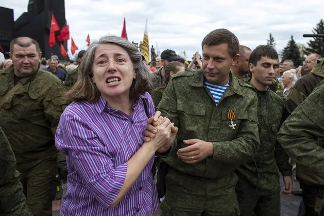 A woman holds the hand of the prime minister of the rebels' self-proclaimed Donetsk People's Republic (DNR), Alexander Zakharchenko (R), during a ceremony to honour the World War Two defenders of Donetsk from Nazi forces in Donetsk, in this September 8, 2014 file photo. (Photo by Marko Djurica/Reuters)