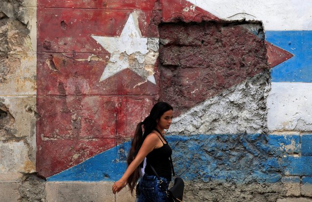 A woman walks in front of a mural of the Cuban flag in Havana, Cuba, November 26, 2016. (Photo by Enrique de la Osa/Reuters)