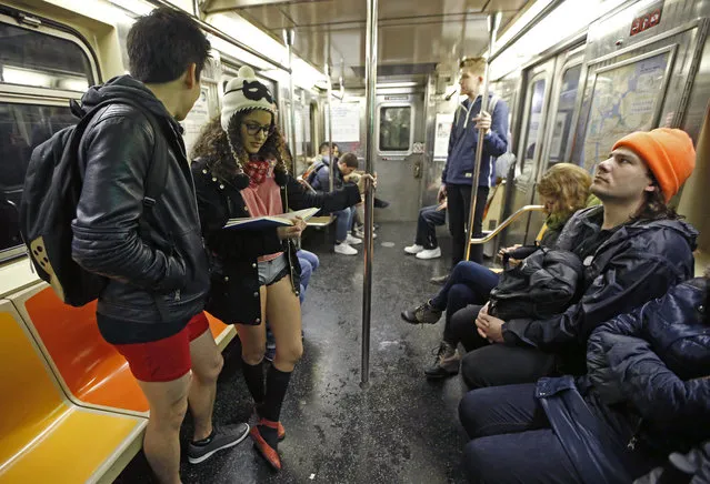 Two people ride a 6 train during the 15th annual No Pants Subway Ride Sunday, January 10, 2016, in New York. (Photo by Kathy Willens/AP Photo)