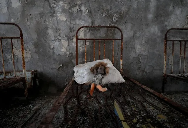 A vintage doll, which was placed by a visitor, is seen on a bed at a kindergarten near the Chernobyl Nuclear Power Plant in the abandoned city of Pripyat, Ukraine on April 12, 2021. (Photo by Gleb Garanich/Reuters)
