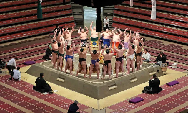 Sumo wrestlers huddle in the ring at the start of the first day of a new two-week sumo tournament in Tokyo on May 9, 2021, with no spectators due to the COVID-19 state of emergency in the Japanese capital. (Photo by JIJI Press/AFP Photo)