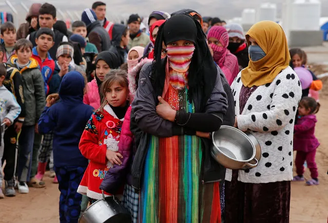 People who fled the Islamic State stronghold of Mosul, stand in line to receive food at a refugee camp, Iraq,December 18, 2016. (Photo by Ammar Awad/Reuters)