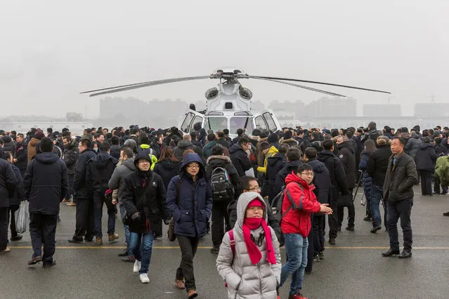 People takes pictures of the Chinese AC352 after the helicopter made a maiden flight in Harbin, Heilongjiang province, China December 20, 2016. (Photo by Reuters/China Daily)