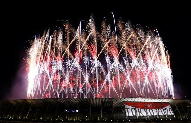 Fireworks go off around the Olympic Stadium after the lighting of the Olympic Flame during the opening ceremony of the Tokyo 2020 Olympic Games, in Tokyo, on July 23, 2021. (Photo by Edgar Su/Reuters)