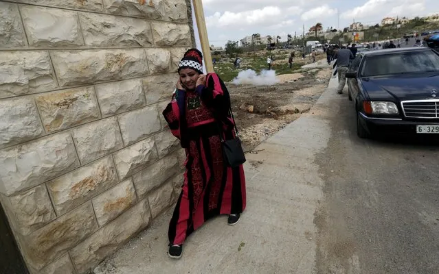 A Palestinian woman reacts to sound of grenades fired by Israeli troops during clashes following a protest marking the Land Day and against Jewish settlements in the West Bank village of Silwad near Ramallah March 30, 2015. Palestinians mark Land Day on March 30, the annual commemoration of protests in 1976 against Israel's appropriation of Arab-owned land in the Galilee. (Photo by Mohamad Torokman/Reuters)