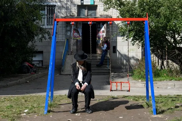 An Ultra-Orthodox Jewish pilgrim sits in a swing near the tomb of Rabbi Nachman of Breslov during the celebration of Rosh Hashanah holiday, the Jewish New Year, amid Russia's attack on Ukraine, in Uman, Ukraine on September 25, 2022. (Photo by Vladyslav Musiienko/Reuters)