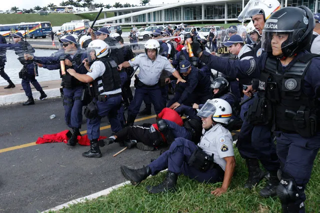 Military police officers keep back demonstrators with pepper spray as they detain a worker during a protest in front the Congress building, in Brasilia, Brazil, Tuesday, April 7, 2015. (Photo by Eraldo Peres/AP Photo)