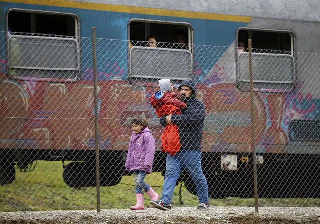 Migrants walk along a train upon their arrival at a makeshift train station close to the Austrian border town of Spielfeld in the village of Sentilj, Slovenia, February 16, 2016. (Photo by Leonhard Foeger/Reuters)