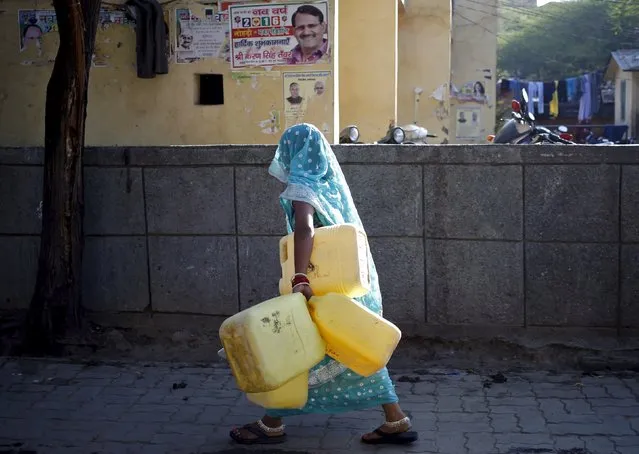 A woman carries empty containers to fetch water from a municipal water tap in New Delhi, India, February 21, 2016. (Photo by Anindito Mukherjee/Reuters)