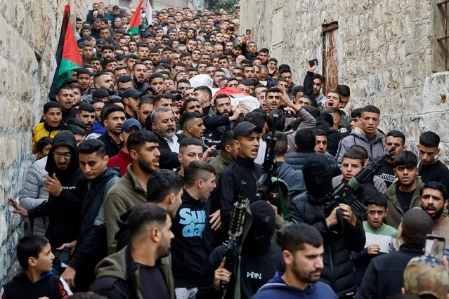 Armed men hold their weapons during the funeral of Palestinian Omar Abu Baker, 16, who was killed in an Israeli raid, near Jenin in the Israeli-occupied West Bank on December 7, 2023. (Photo by Raneen Sawafta/Reuters)
