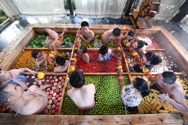 People enjoy a barbecue as they bath in a hotpot-shaped hot spring filled with fruits and vegetables, at hotel in Hangzhou, Zhejiang province, China on January 27, 2019. (Photo by Reuters/China Stringer Network)