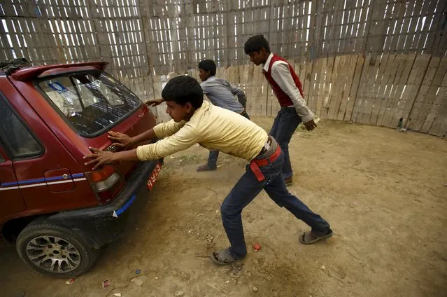 Boys try to push start a car inside the “Well of Death” attraction during a fair in Bhaktapur April 20, 2015. (Photo by Navesh Chitrakar/Reuters)