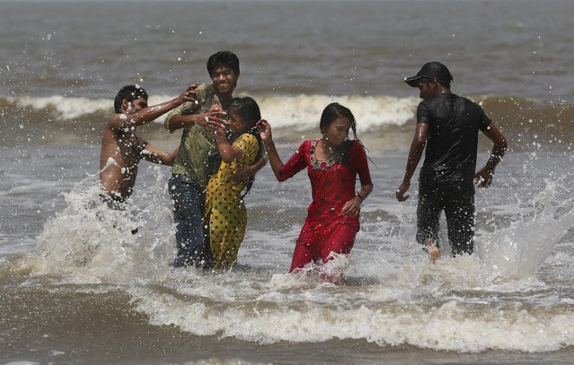 Young Indians play in the Arabian Sea in Mumbai, India, Thursday, April 23, 2015. Bounded by the Arabian Sea to the west, Mumbai is India's commercial capital, largely because of the transformation of the city into a major seaport in the 19th Century. (Photo by Rafiq Maqbool/AP Photo)