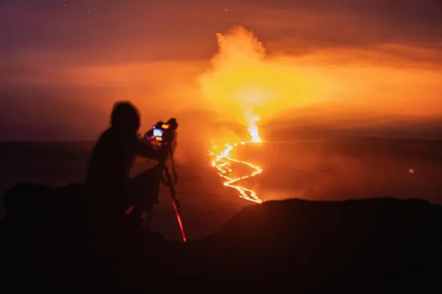 A person sets up a camera to photograph the eruption of the Mauna Loa Volcano in Hawaii, U.S. December 3, 2022. (Photo by Go Nakamura/Reuters)