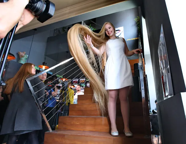Olena Korzeniuk, a 15-year-old girl poses on the stairs during a bid to set the national record for the longest hair on a child in Kiev, Ukraine on March 12, 2019. During a ceremony, the experts of the National Register of Records found the blonde hair of the Ukrainian Rapunzel to be 2.35m (6.5ft) long. (Photo by Tarasov/Ukrinform/Barcroft Images)