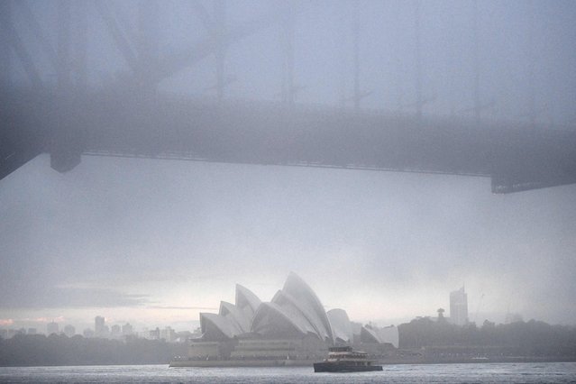 A ferry makes its way in front of the Sydney's iconic Opera House on July 2, 2021 as heavy fog blanketed the city. (Photo by Saeed Khan/AFP Photo)