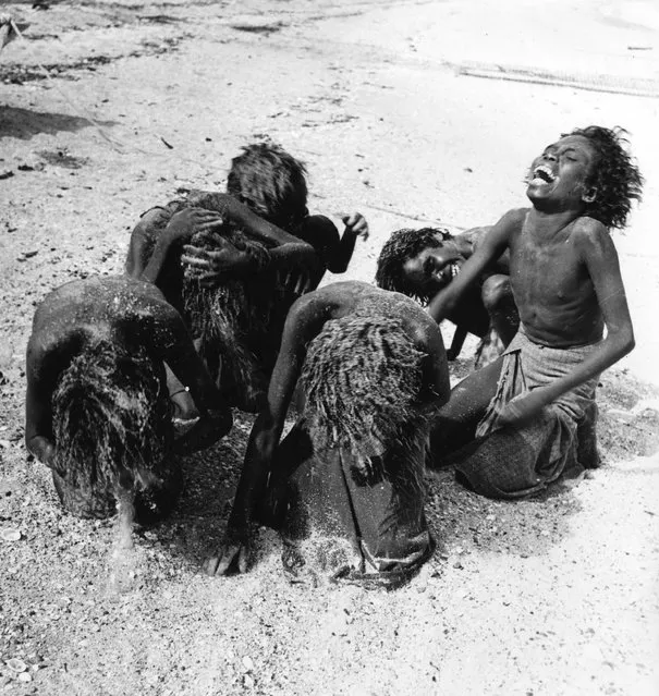 1st January 1950:  Aboriginal women washing their hair with sand at Arnhem land in the Northern Territory of Australia.  (Photo by Three Lions/Getty Images)