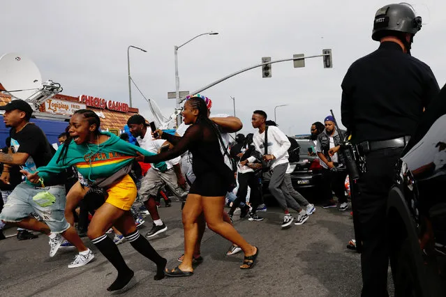 People flee the scene after hearing a loud noise while waiting for a hearse carrying the casket of slain rapper Nipsey Hussle Thursday, April 11, 2019, in Los Angeles. The 25-mile procession traveled through the streets of South Los Angeles, including a trip past Hussle's clothing store, The Marathon, where he was gunned down March 31. (Photo by Patrick T. Fallon/The Sun)