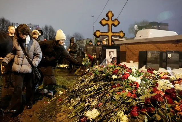 People visit the grave of Russian opposition politician Alexei Navalny following his funeral at the Borisovskoye cemetery in Moscow, Russia, on March 1, 2024. (Photo by Reuters/Stringer)