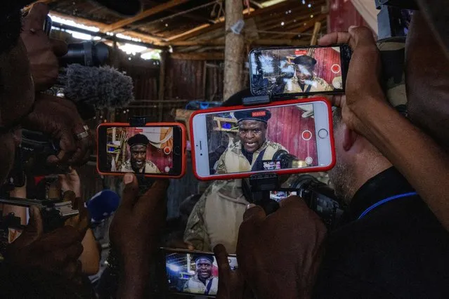 Journalists film former police officer Jimmy “Barbecue“ Cherizier, leader of the “G9” coalition, as he gives a media tour of the La Saline shanty area of Port-au-Prince, Haiti on November 3, 2021. (Photo by Adrees Latif/Reuters)