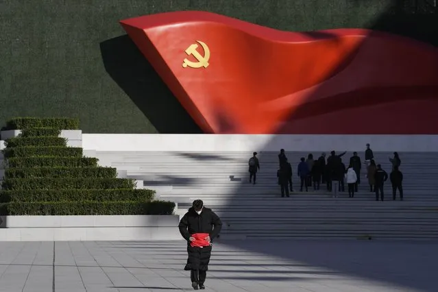 A worker folds a flag near a sculpture of the Chinese Communist Party flag outside the Museum of the Communist Party of China here in Beijing, China, Friday, November 12, 2021. Chinese leader Xi Jinping emerges from a party conclave this week not only more firmly ensconced in power than ever, but also with a stronger ideological and theoretical grasp on the ruling Communist Party's past, present and future. (Photo by Ng Han Guan/AP Photo)