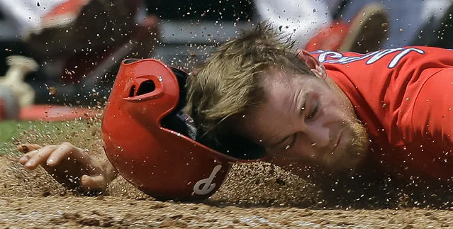 Philadelphia Phillies' Ryan Jackson loses his helmet as he hits the dirt after getting tagged out by Detroit Tigers catcher Jarrod Saltalamacchia during the third inning of a spring training baseball game Saturday, March 26, 2016, in Clearwater, Fla. Jackson was out trying to score on a fly out by Andres Blanco to Tigers right fielder Tyler Collins. (Photo by Chris O'Meara/AP Photo)
