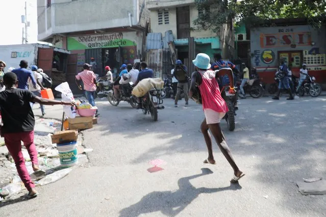 Residents run after hearing gunfire as the government said it would extend a state of emergency for another month after an escalation in violence from gangs seeking to oust the Prime Minister Ariel Henry, in Port-au-Prince, Haiti, on March 7, 2024. (Photo by Ralph Tedy Erol/Reuters)