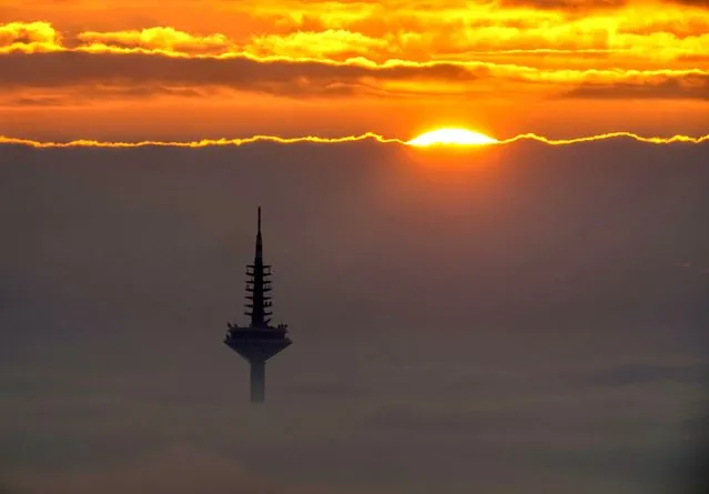 The television tower looks out of the thick fog that covers Frankfurt, Germany, during sunrise on Saturday, November 6, 2021. (Photo by Michael Probst/AP Photo)