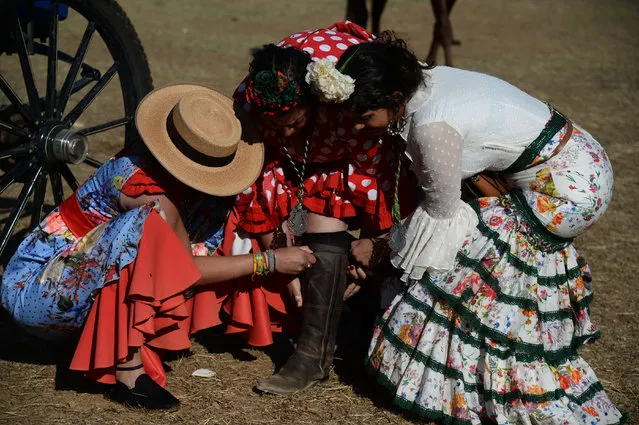 Pilgrims rest on June 6, 2019 in Villamanrique, during a pilgrimage to the village of El Rocio. El Rocio pilgrimage, the largest in Spain, gathers hundreds of thousands of devotees in traditional outfits converging in a burst of colour as they make their way on horseback and on board decorated carriages across the Andalusian countryside. (Photo by Cristina Quicler/AFP Photo)