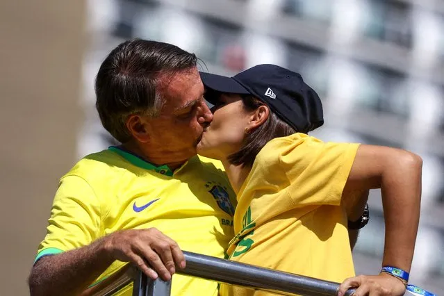 Brazil's former President Jair Bolsonaro and his wife Michelle Bolsonaro kiss as they attend a demonstration in Copacabana, where he called his supporters to gather, as police investigate him for allegedly plotting a coup after the 2022 election, in Rio de Janeiro, Brazil on April 21, 2024. (Photo by Pilar Olivares/Reuters)
