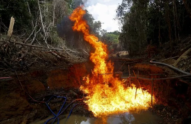 An illegal gold mine burns during Brazil’s environmental agency operation against illegal gold mining on indigenous land, in the heart of the Amazon rainforest, in Roraima state, Brazil April 17, 2016. (Photo by Bruno Kelly/Reuters)