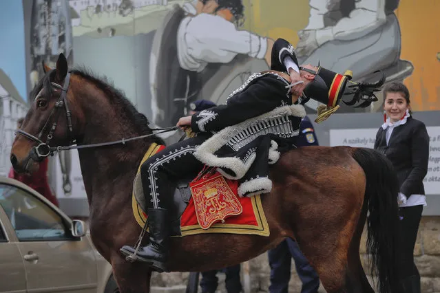 An Ethnic Hungarian wearing a Hussar uniform leans back on his horse before a parade in Targu Secuiesc, Romania, Wednesday, March 15, 2017. Thousands of ethnic Hungarians paraded in Romania to celebrate the Hungarian national holiday, marking the anniversary of the 1848 revolution against the Habsburg empire. (Photo by Vadim Ghirda/AP Photo)