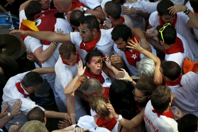 Revellers squeeze alongside one another as they sing, dance and drink during the traditional Riau-Riau dance from the town hall to the Saint Fermin Chapel at San Lorenzo church on the first day of the San Fermin Festival in Pamplona, Spain, July 6, 2015. (Photo by Susana Vera/Reuters)